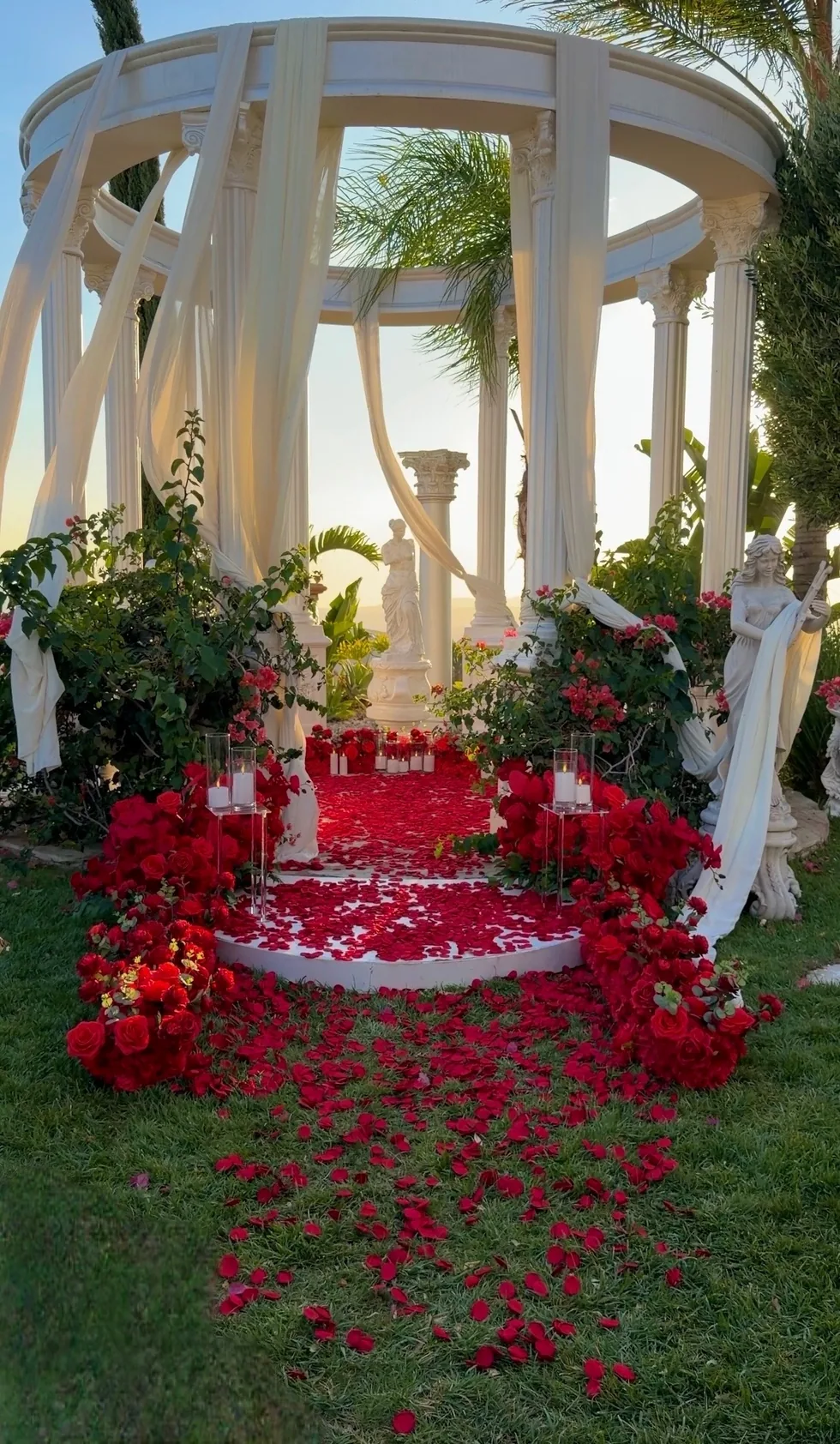 Romantic red rose setup with candles and draped garden columns